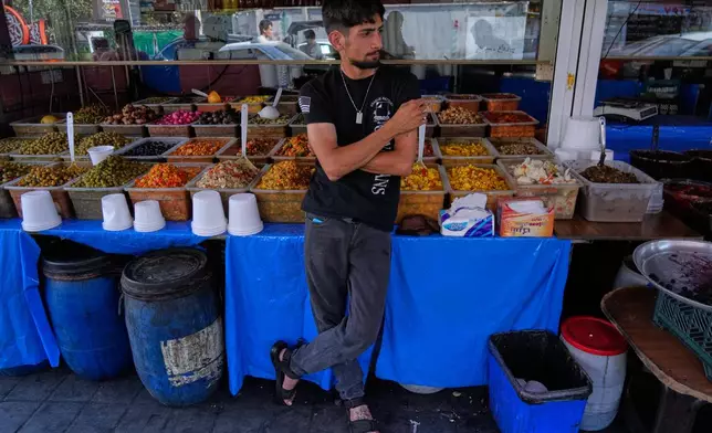 A vendor waits for customer outside his shop in Tehran, Iran, Monday, Aug. 10, 2026. (AP Photo/Vahid Salemi)