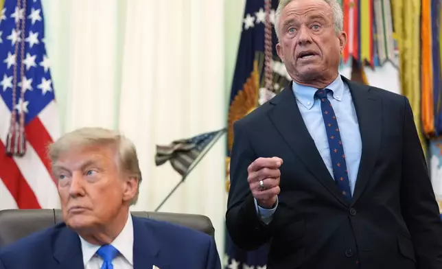 Health and Human Services Secretary Robert F. Kennedy Jr. speaks as President Donald Trump listens during a meeting to sign an executive order about vaccines, Monday, Aug. 10, 2026, in the Oval Office of the White House in Washington. (AP Photo/Jacquelyn Martin)
