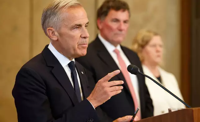 Canada-U.S. Trade Minister Dominic LeBlanc and chief trade negotiator Janice Charette listen as Prime Minister Mark Carney speaks about Canada's response to new U.S. tariffs during a news conference on Parliament Hill in Ottawa on Saturday, Aug. 22, 2026. (Patrick Doyle/The Canadian Press via AP)