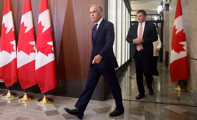 Prime Minister Mark Carney and Canada-U.S. Trade Minister Dominic LeBlanc arrive at a news conference about Canada's response to new U.S. tariffs on Parliament Hill in Ottawa on Saturday, Aug. 22, 2026. (Patrick Doyle/The Canadian Press via AP)