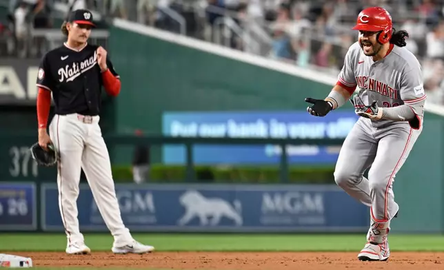 Cincinnati Reds' Eugenio Suárez, right, celebrates after his solo home run as he runs by Washington Nationals third baseman Brady House during the second inning of a baseball game, Friday, Aug. 7, 2026, in Washington. (AP Photo/John McDonnell)