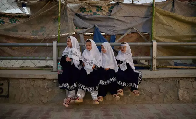 Four young girls dressed in matching outfits hold Taliban flags on the eve of the fifth anniversary of the U.S. withdrawal and the start of Taliban rule in Kabul, Afghanistan, Friday, Aug. 14, 2026. (AP Photo/Nava Jamshidi)