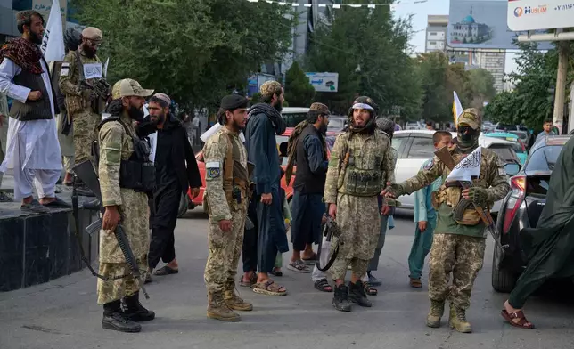 Armed Taliban police stand along a street ahead of celebrations marking the fifth anniversary of the U.S. withdrawal and the start of Taliban rule in Kabul, Afghanistan, Friday, Aug. 14, 2026. (AP Photo/Nava Jamshidi)