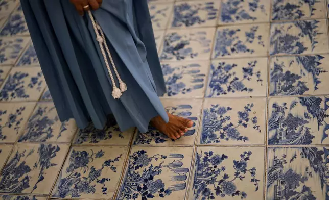 A nun walks through the main hall with its blue-and-white Chinese porcelain tile floor at the 458-year-old Paradesi Synagogue in the historic Jew Town neighborhood of Kochi, India, Wednesday, May 20, 2026. (AP Photo/Aijaz Rahi)
