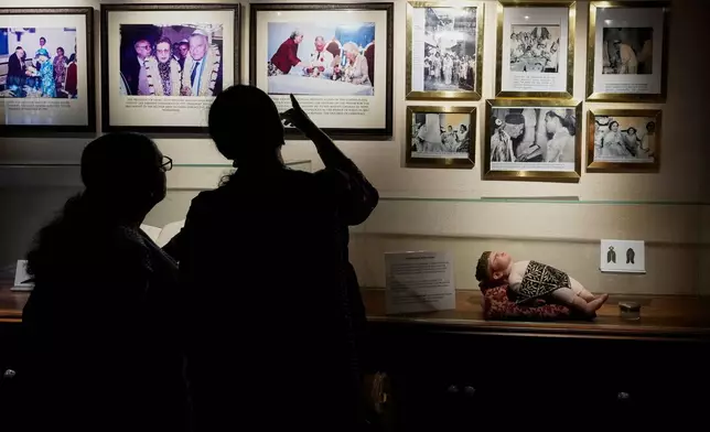Visitors view photos displayed inside a museum showcasing Cochin's Jewish history next to the 458-year-old Paradesi Synagogue in the historic Jew Town neighborhood of Kochi, India, Wednesday, May 20, 2026. (AP Photo/Aijaz Rahi)