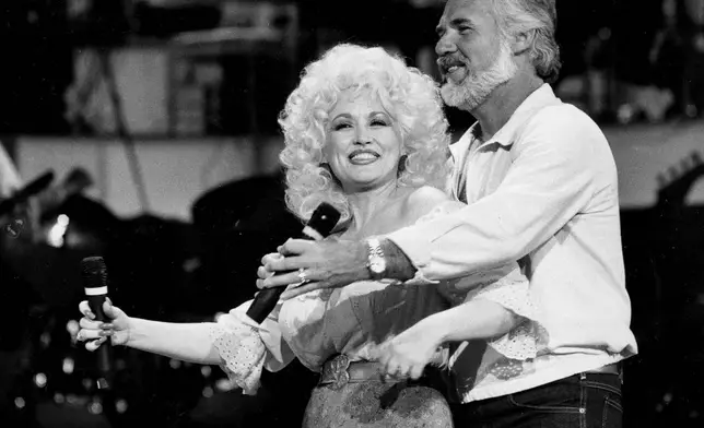 FILE - Dolly Parton, left, and Kenny Rogers rehearse a song for their appearance on the TV show "Live... And in Person" in Los Angeles on Sept. 27, 1983. (AP Photo/Doug Pizac, File)