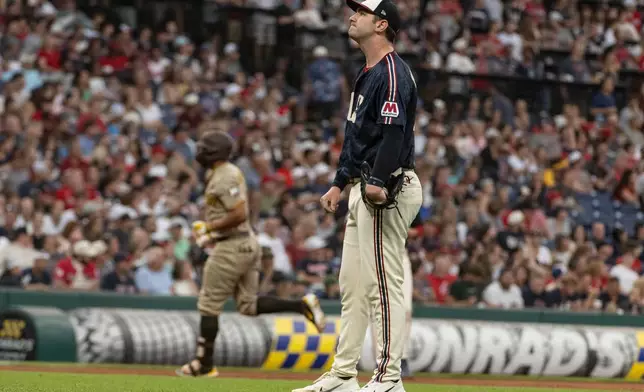 Cleveland Guardians starting pitcher Gavin Williams, front, reacts after giving up a two-run home run to San Diego Padres' Xander Bogaerts, rear, during the fourth inning of a baseball game, Friday, Aug. 14, 2026, in Cleveland. (AP Photo/Phil Long)