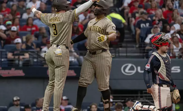 San Diego Padres' Jackson Merrill (3) congratulates Xander Bogaerts, center, after Bogaerts hit a two-run home run off Cleveland Guardians starting pitcher Gavin Williams during the fourth inning of a baseball game, Friday, Aug. 14, 2026, in Cleveland. (AP Photo/Phil Long)