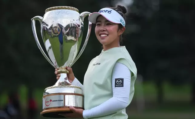 Miyu Yamashita, of Japan, celebrates with the trophy after winning the LPGA Canadian Women's Open golf tournament in Edmonton, Alberta, Sunday, Aug. 23, 2026. (Darryl Dyck/The Canadian Press via AP)