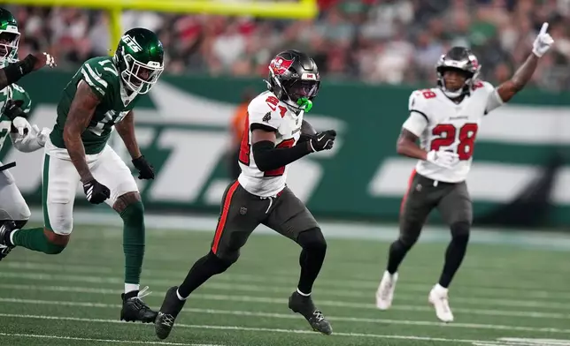 Tampa Bay Buccaneers cornerback Ayden Garnes (24) runs from New York Jets wide receiver Tim Patrick (17) while returning an interception for a touchdown during the first half of a preseason NFL football game, Friday, Aug. 14, 2026, in East Rutherford, N.J. (AP Photo/Frank Franklin II)