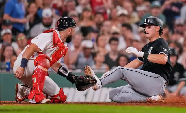 Chicago White Sox's Colson Montgomery, right, beats the tag by Boston Red Sox's Connor Wong to score on a single Braden Montgomery during the fifth inning of a baseball game, Thursday, Aug. 6, 2026, in Boston. (AP Photo/Charles Krupa)