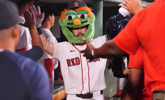 Boston Red Sox's Connor Wong is congratulated after his two-run home run during the third inning of a baseball game against the Chicago White Sox, Thursday, Aug. 6, 2026, in Boston. (AP Photo/Charles Krupa)