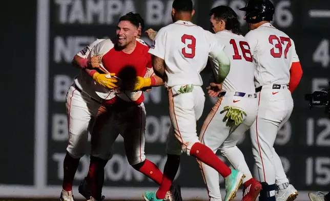 Boston Red Sox's Caleb Durbin, left, celebrates with teammates after his game-winning RBI single during the 13th inning of a baseball game against the Chicago White Sox, Thursday, Aug. 6, 2026, in Boston. (AP Photo/Charles Krupa)