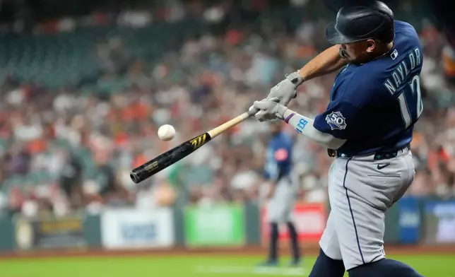 Seattle Mariners' Josh Naylor hits a sacrifice fly against the Houston Astros during the first inning of a baseball game Friday, Aug. 14, 2026, in Houston. (AP Photo/David J. Phillip)