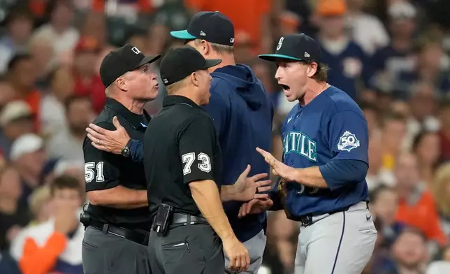 Seattle Mariners third baseman Brendan Donovan, right, and manager Dan Wilson argue with umpires Marvin Hudson (51) and Tripp Gibson (73) during the second inning of a baseball game against the Houston Astros Friday, Aug. 14, 2026, in Houston. (AP Photo/David J. Phillip)