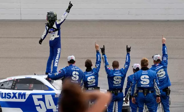 Ty Gibbs, top, celebrates with crew members after winning a NASCAR Cup Series auto race, Sunday, Aug. 9, 2026, at Iowa Speedway in Newton, Iowa. (AP Photo/Charlie Neibergall)