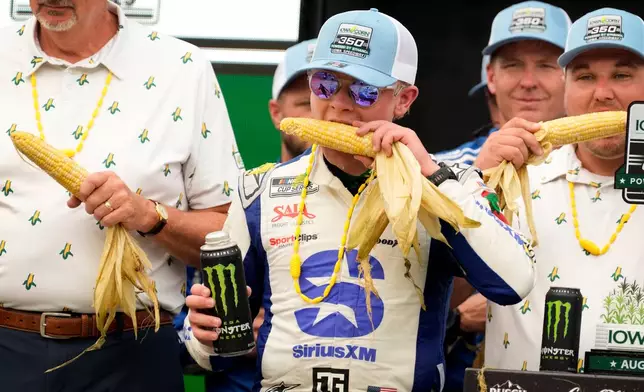 Ty Gibbs eats corn after winning a NASCAR Cup Series auto race, Sunday, Aug. 9, 2026, at Iowa Speedway in Newton, Iowa. (AP Photo/Charlie Neibergall)