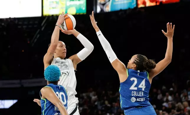 Las Vegas Aces center A'ja Wilson (22) shoots between Minnesota Lynx guard Courtney Williams (10) and forward Napheesa Collier (24) during the first half of a WNBA basketball game Saturday, Aug. 15, 2026, in Las Vegas. (Steve Marcus/Las Vegas Sun via AP)