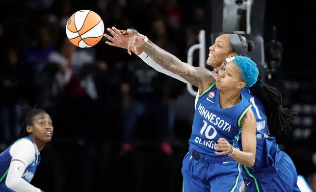 Minnesota Lynx forward Natasha Howard (1) and guard Courtney Williams (10) jump in an attempt to block a shot by Las Vegas Aces center A'ja Wilson during the first half of a WNBA basketball game Saturday, Aug. 15, 2026, in Las Vegas. (Steve Marcus/Las Vegas Sun via AP)