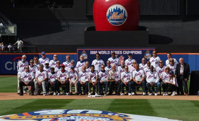Members of the 1986 New York Mets team that won a World Series and family members pose for a group photo during a reunion celebration for the team, Saturday, Aug. 1, 2026, in New York. (AP Photo/Heather Khalifa)
