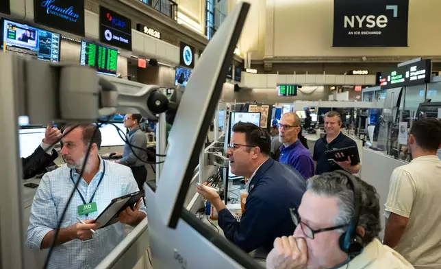 Options traders work on the floor of the New York Stock Exchange in New York, Friday, Aug. 21, 2026. (AP Photo/Yuki Iwamura)