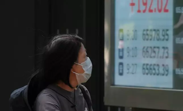 A person walks by an electronic stock board showing Japan's Nikkei index at a securities firm Monday, Aug. 24, 2026, in Tokyo. (AP Photo/Eugene Hoshiko)