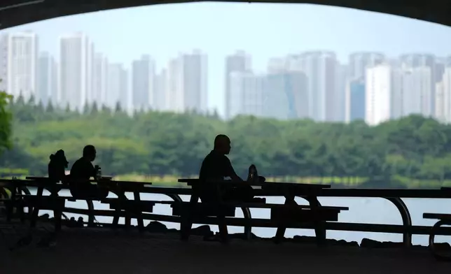 People sit in the shade to avoid the heat in Goyang, South Korea, Wednesday, Aug. 5, 2026. (AP Photo/Lee Jin-man)