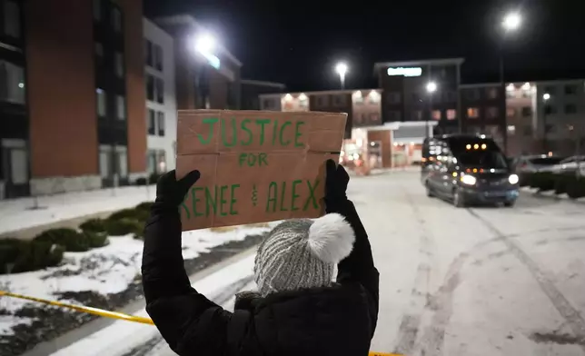 FILE - A demonstrator holds a sign reading "Justice for Renee & Alex" during a protest outside a SpringHill Suites and Residence Inn by Marriott hotels, Jan. 26, 2026, in Maple Grove, Minn. (AP Photo/Adam Gray, File)