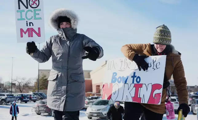 FILE - Protesters stand on the side of the road with ICE protest signs, Jan. 19, 2026, in St. Paul, Minn. (AP Photo/Angelina Katsanis, File)