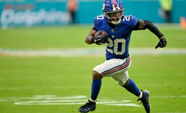 New York Giants running back Eric Gray (20) runs the ball during the second half of a preseason NFL football game against the Miami Dolphins, Saturday, Aug. 22, 2026, in Miami Gardens, Fla. (AP Photo/Doug Murray)