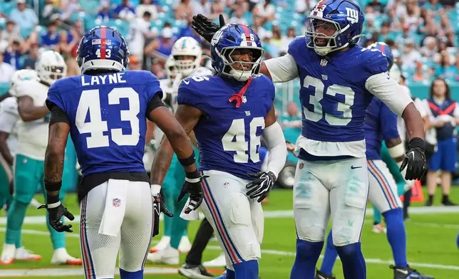 New York Giants linebacker Zaire Barnes (46) celebrates with Giants linebacker Caleb Murphy (33) during the second half of a preseason NFL football game against the Miami Dolphins, Saturday, Aug. 22, 2026, in Miami Gardens, Fla. (AP Photo/Lynne Sladky)