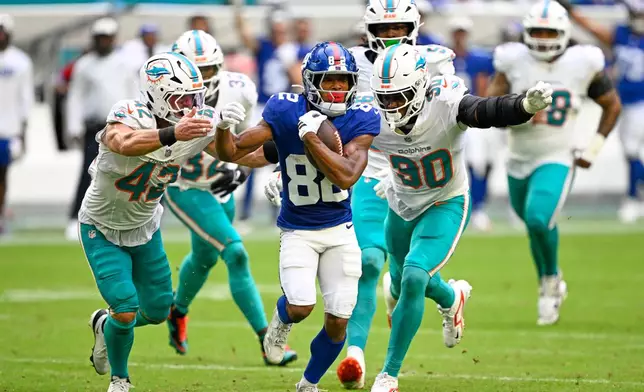New York Giants wide receiver Calvin Austin III (82) runs the ball during the first half of a preseason NFL football game against the Miami Dolphins, Saturday, Aug. 22, 2026, in Miami Gardens, Fla. (AP Photo/Doug Murray)