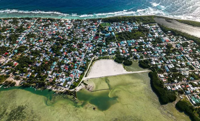 Mangroves line the shore of Hithadhoo Island, part of a UNESCO Biosphere Reserve, with reclamation work visible through it in Addu City, Maldives, June 5, 2026, (AP Photo/Sophia Nasif)