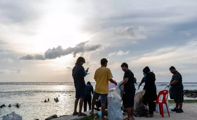 Ripple, a youth group, joins an early morning beach clean up organized by the Ministry of Youth, on Dhiraagu Beach in Hulhumale, Maldives, June 12, 2026. (AP Photo/Sophia Nasif)
