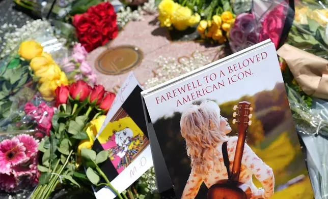 Dolly Parton's star on the Hollywood Walk of Fame is decorated with flowers Tuesday, Aug. 25, 2026, in Los Angeles. (AP Photo/Chris Pizzello)