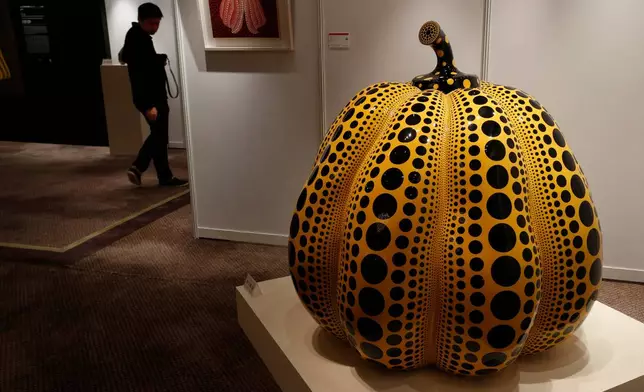 FILE - A man walks past a work " Pumpkin " by Japanese artist Yayoi Kusama during the Ravenel auction press preview in Hong Kong Friday, Nov. 23, 2012. (AP Photo/Vincent Yu, File)