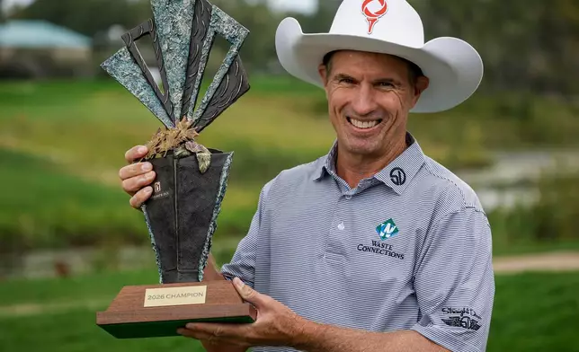 New Zealand's Stephen Alker lifts the trophy after winning the PGA Tour Champions golf event in Calgary, Alberta, Sunday, Aug. 23, 2026. (Jeff McIntosh/The Canadian Press via AP)