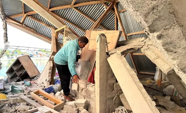 Arshad Hamid, an earthquake survivor, looks for valuable in his damaged house in North Lamba Leda, East Nusa Tenggara province, Indonesia, Wednesday, Aug. 19, 2026. (AP Photo/Firdia Lisnawati)