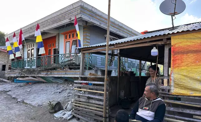 People sit near a house collapsed during an earthquake in North Lamba Leda, East Nusa Tenggara province, Indonesia, Wednesday, Aug. 19, 2026. (AP Photo/Firdia Lisnawati)