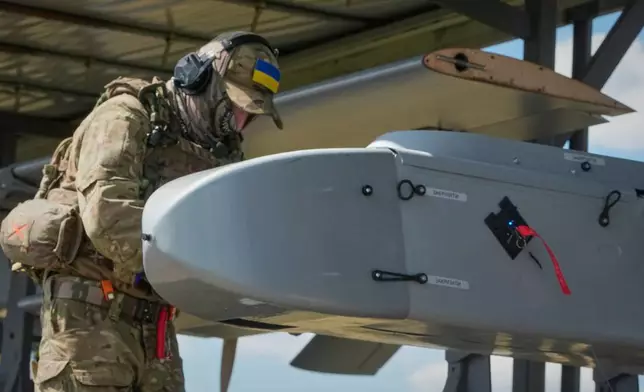 A soldier of Ukraine's 413th Separate Regiment of Unmanned Systems "Raid" prepares an FP-1 long-range attack drone to be launched on a deep-strike drone mission to hit Russian targets deep in their territory, in an undisclosed location in Ukraine, Sunday, Aug. 16, 2026. (AP Photo/Efrem Lukatsky)