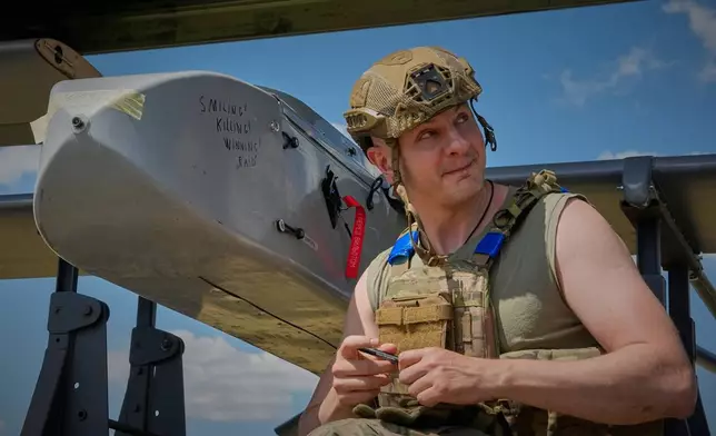 Yevhen Karas, commander of Ukraine's 413th Separate Regiment of Unmanned Systems "Raid," writes a message on an FP-1 long-range attack drone on a deep-strike drone mission to hit Russian targets deep in their territory, in an undisclosed location in Ukraine, Sunday, Aug. 16, 2026. (AP Photo/Efrem Lukatsky)