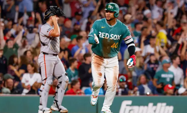 Boston Red Sox's Willson Contreras, right, reacts after hitting a three-run home run during the third inning of a baseball game against the San Francisco Giants, Friday, Aug. 21, 2026, in Boston. (AP Photo/Greg M. Cooper)