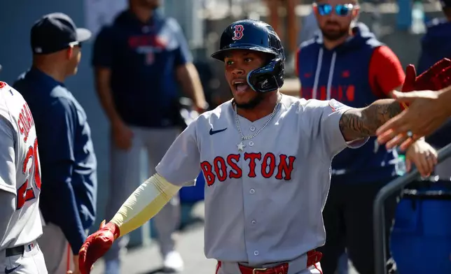Boston Red Sox's Ceddanne Rafaela is greeted by teammates after scoring on a single hit by Sox's designated hitter Masataka Yoshida during the first inning of a baseball game, Sunday, Aug. 2, 2026, in Los Angeles. (AP Photo/Caroline Brehman)
