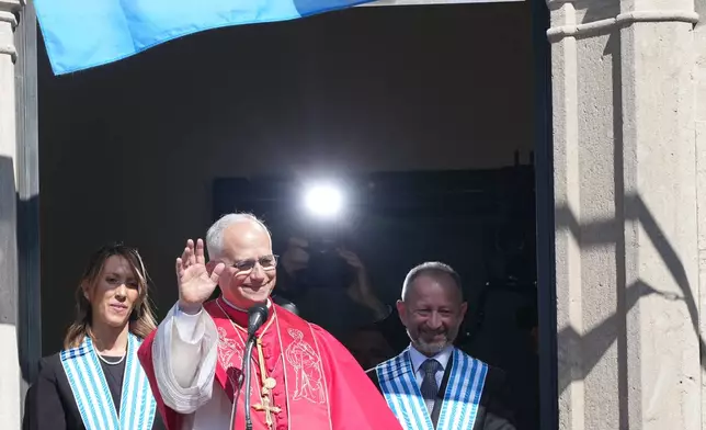Pope Leo XIV, center, flanked by Captains Regent Alice Mina, left, and Vladimiro Selva, waves to faithful from the balcony of Palazzo Pubblico (City Hall) during his visit to San Marino, Saturday, Aug. 22, 2026. (AP Photo/Andrew Medichini)