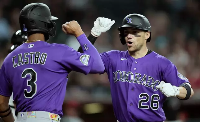 Colorado Rockies' Brett Sullivan (26) celebrates his three-run home run against the Arizona Diamondbacks with Rockies' Willi Castro (3) during the second inning of a baseball game, Wednesday, Aug. 12, 2026, in Phoenix. (AP Photo/Ross D. Franklin)