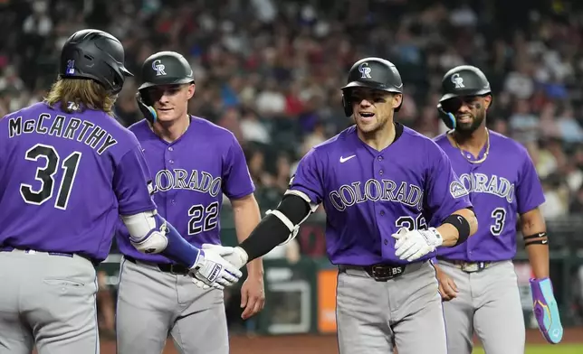 Colorado Rockies' Brett Sullivan, second from right, celebrates his three-run home run against the Arizona Diamondbacks with Rockies' Jake McCarthy (31), Mickey Moniak (22) and Willi Castro (3) during the second inning of a baseball game, Wednesday, Aug. 12, 2026, in Phoenix. (AP Photo/Ross D. Franklin)