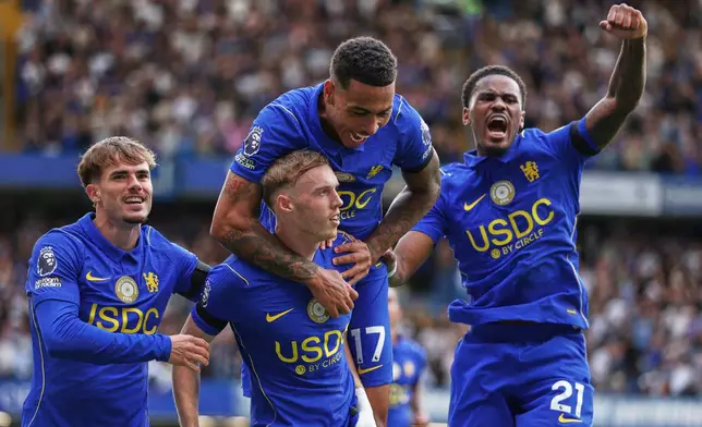 Chelsea's Cole Palmer, centre, celebrates with teammates after scoring his side's fourth goal during the English Premier League soccer match between Chelsea and Brighton and Hove Albion in London, Sunday, Aug. 30, 2026. (AP Photo/Ian Walton)