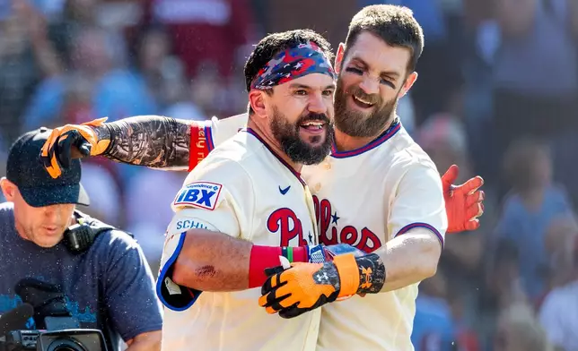 Philadelphia Phillies' Kyle Schwarber, left, and Bryce Harper celebrate after Schwarber hit the game winning home run in the ninth inning of a baseball game against the St. Louis Cardinals, Sunday, Aug. 23, 2026, in Philadelphia. (AP Photo/Laurence Kesterson)