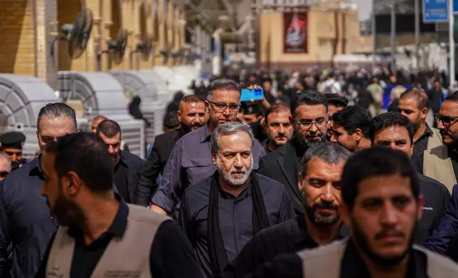 Iran's Foreign Minister Abbas Araghchi, center, is surrounded by security personnel as he walks in Najaf, Iraq, during Arbaeen commemorations, Monday, Aug. 3, 2026. (AP Photo/Anmar Khalil)