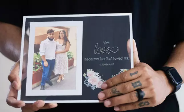 Army Sgt. Hedar Leonel Turcios Juarez holds a picture of himself with with his wife Cristy, who is currently on immigration detention, at home in El Paso, Texas, July 21, 2026. (AP Photo/Ryan Romero)